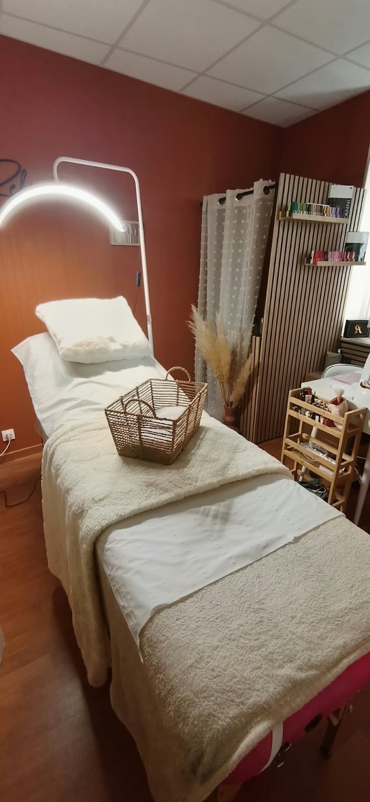 Les deux lits de soin de l'institut, murs terracotta et rangements en bois